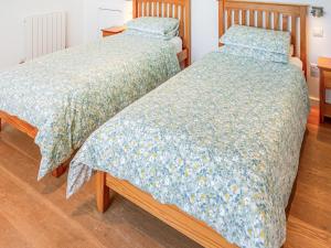 two beds sitting next to each other in a bedroom at The Longhouse At Threave in Castle Douglas +13 photos