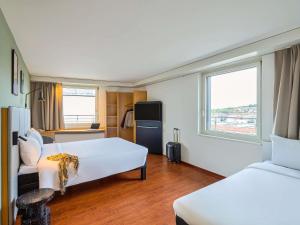 a hotel room with two beds and a window at ibis Baar Zug in Zug +61 photos