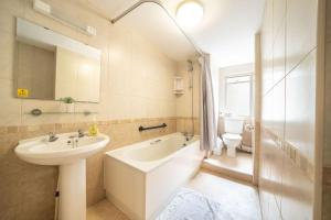 a bathroom with a sink and a tub and a toilet at Lelola Lodge in Bournemouth +76 photos