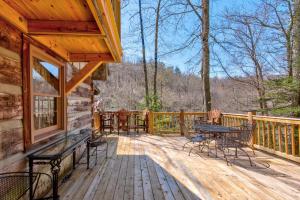 a wooden deck with a table and chairs on it at Creeksong Cabin in Elk Park