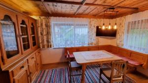 a dining room with a table and chairs and windows at Haus Harmonie in Kaltenbach
