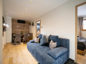 a living room with a blue couch and a dining room at Appartement Krismer in Fügen