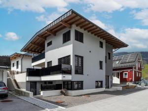 a white house with a gambrel roof at Appartement Krismer in Fügen