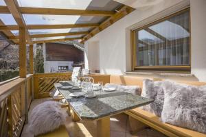 a table and chairs on a balcony with a window at Haus Gondelspaß in Fügen