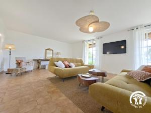 ein Wohnzimmer mit zwei Sofas und einem Flachbildfernseher in der Unterkunft A Villandré in Barcugnan