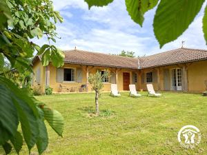 ein Haus mit Liegestühlen im Garten in der Unterkunft A Villandré in Barcugnan