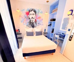 a bedroom with a bed and a painting of a man at Hotel La Petite Rosa in Paris