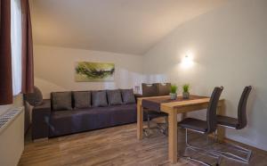 a living room with a couch and a table at Appartements Rosmarie Hollaus in Fügenberg