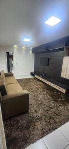 a living room with a couch and a flat screen tv at Casa confortável para o são joão in Campina Grande