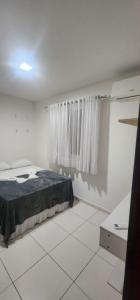 a white room with a bed and a window at Casa confortável para o são joão in Campina Grande