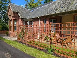 a wooden fence in front of a house at Mulberry Lodge -- a luxury cottage on the West Highland Way in Drymen