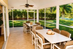 a dining room with tables and chairs and windows at SWISS 24 - Lake Stephanie in Clermont