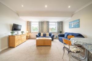 a living room with a blue couch and a tv at Lelola Lodge in Bournemouth