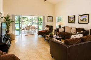 a living room with couches and a table and a dining room at SWISS 24 - Lake Stephanie in Clermont
