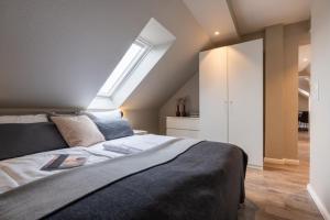a bedroom with a large bed with a skylight at Pier17 Appartement 6 in Borkum