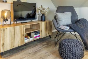 a living room with a tv and a chair at Pier17 Appartement 6 in Borkum +5 photos