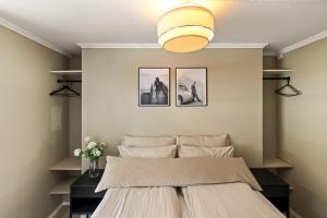 a bedroom with a bed and a light fixture at Koselig leilighet midt i Tønsberg in Tønsberg