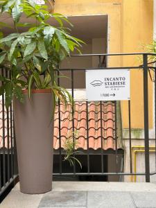 a plant in a pot on a fence with a sign at Incanto Stabiese in Castellammare di Stabia