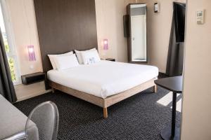 a bedroom with a large white bed in a room at Kyriad Charleville Mezieres in Charleville-Mézières +37 photos