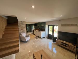 a large living room with a television and a kitchen at Les maisons de Palis in Salvagnac-Cajarc