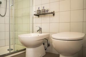 a bathroom with a toilet and a sink and a shower at La corte del Lago in Sulzano +29 photos