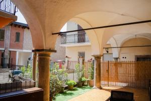 an outdoor patio with arches and potted plants at La corte del Lago in Sulzano