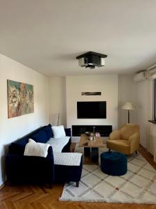 a living room with a blue couch and a chair at Golden Apartment in Travnik