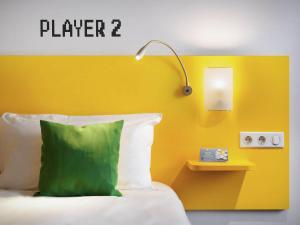 a bed with a green pillow and a yellow wall at Ibis Styles Budapest Center in Budapest +52 photos