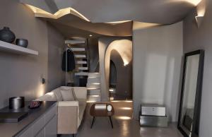 a living room with a spiral staircase and a couch at Kivotos Santorini - Preferred Hotels & Resorts in Imerovigli
