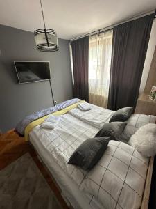 a bedroom with a bed with pillows on it at Golden Apartment in Travnik