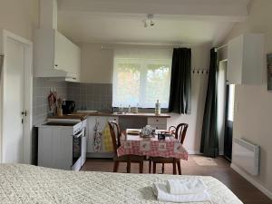 a kitchen with a table and chairs in a room at Le Pavillon in Céroux-Mousty