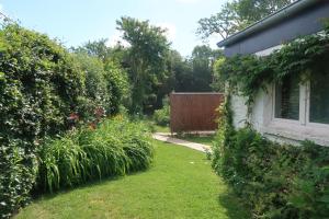 a garden next to a house with a fence at Le Pavillon in Céroux-Mousty