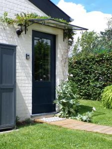 a blue door on a house with a garden at Le Pavillon in Céroux-Mousty +2 photos