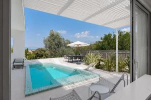 a swimming pool on a patio with a table and chairs at White Pearl Villa in Tivat