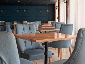 a conference room with wooden tables and blue chairs at Mercure Ismailia Forsan Island in Ismailia +205 photos