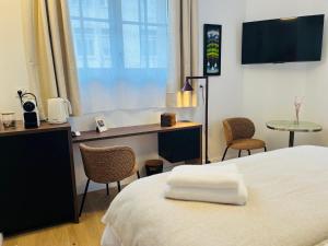a bedroom with a bed and a desk with a computer at La Maison Kerguelen - Suite in Quimper