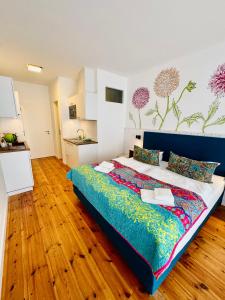 a bedroom with a large bed in a room with wooden floors at Waldschenke Stendenitz Übernachten im Wald am See in Neuruppin