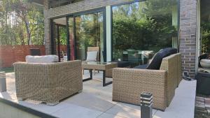 a patio with two wicker chairs and a table at Kamińsko 544 in Kamińsko