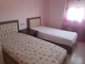 two beds sitting next to each other in a bedroom at Familja Kapaj in Polisi i Vogël