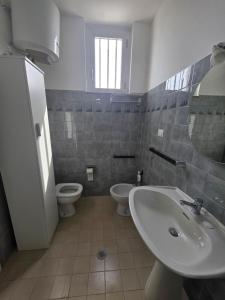 a bathroom with a sink and a toilet and a mirror at Monolocale 100metri dal mare in Fano +11 photos