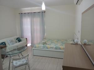 a living room with a bed and a table at Seaview Holiday Studio Peyia in Peyia