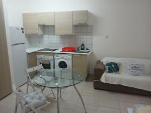 a small kitchen with a glass table and a couch at Seaview Holiday Studio Peyia in Peyia