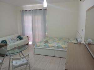a small room with a bed and a glass table at Seaview Holiday Studio Peyia in Peyia