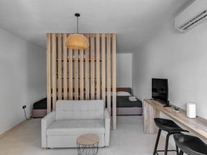 a living room with a white chair and a bed at Βlue Lagoon G6 in Galissas