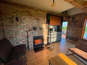 a living room with a brick wall with a fireplace at Sunset sauna Bauska in Jumprava