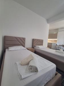 a bedroom with two beds with towels on them at Old Village Apartment in Dhërmi