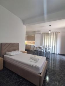 a bedroom with a large bed and a kitchen at Old Village Apartment in Dhërmi