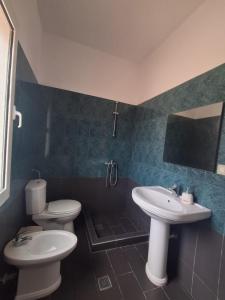 a bathroom with two toilets and a sink at Old Village Apartment in Dhërmi