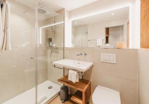 a bathroom with a sink and a shower at Hotel Edelweiss Superior in Mürren +49 photos