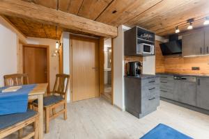 a kitchen and dining room with a table and chairs at Das kleine Bio Hotel Tiefenbach in Schladming